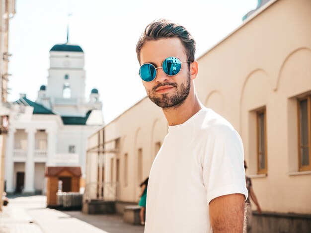 Hombre con gafas de sol con camiseta blanca posando