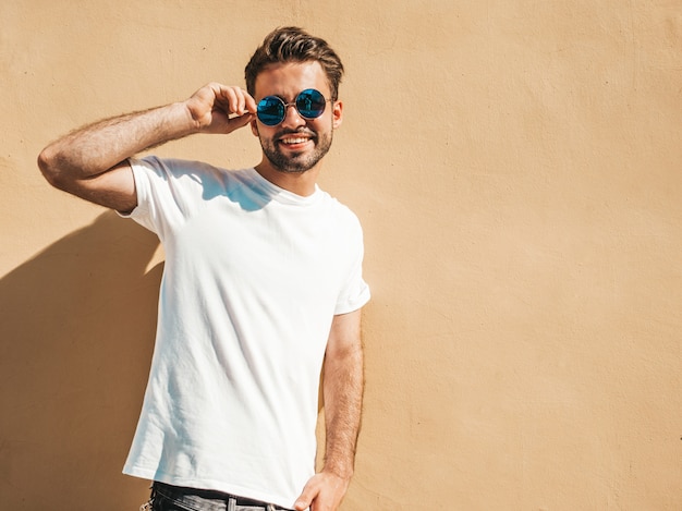 Hombre con gafas de sol con camiseta blanca posando