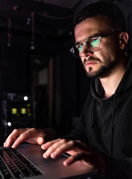 Un hombre con gafas trabaja en una computadora a altas horas de la noche.