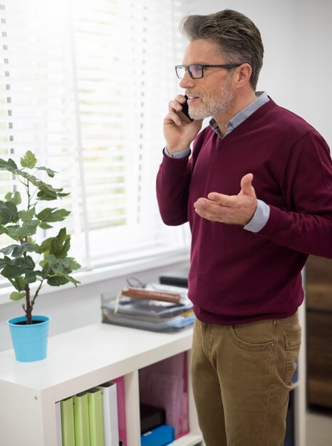 Hombre gesticulando mientras habla por teléfono