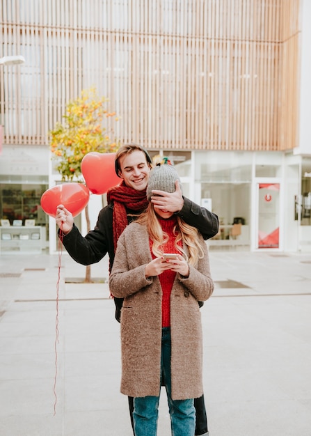 Hombre con globos cerrando los ojos a la novia