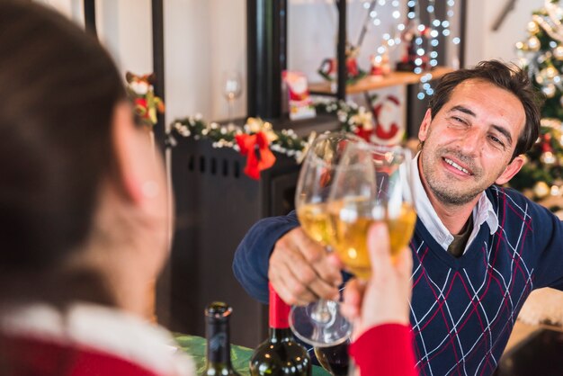 Hombre golpeando copa de vino con mujer