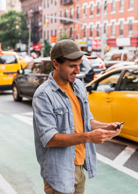 Foto gratuita hombre con gorra mirando móvil