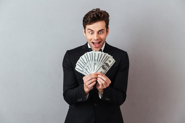 Hombre gritando en traje oficial con dinero.