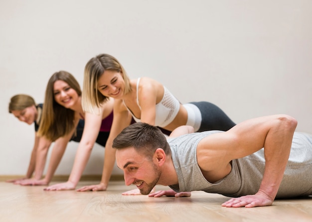 Hombre y grupo de mujeres entrenando juntos