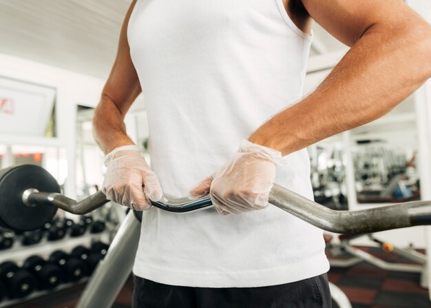 Hombre con guantes trabajando en el gimnasio