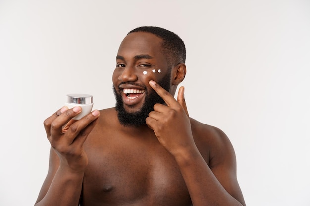 Foto gratuita hombre guapo africano aplicando crema en su rostro mans concepto de cuidado de la piel