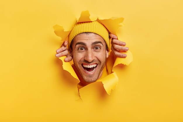 Hombre guapo alegre con sonrisa con dientes, expresión alegre, pared de papel de lágrimas