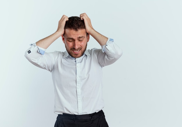 Hombre guapo ansioso tiene la cabeza aislada en la pared blanca