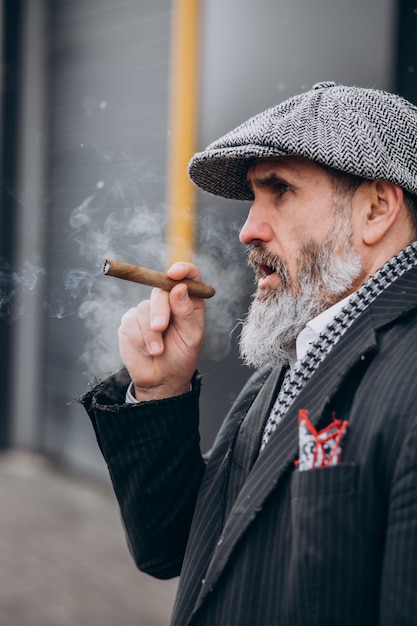 Foto gratuita hombre guapo con barba fumando cigarrillo