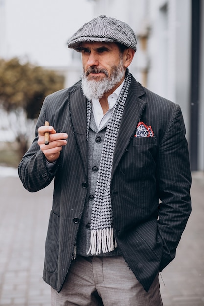 Foto gratuita hombre guapo con barba fumando cigarrillo