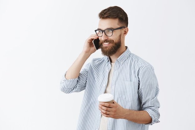 Foto gratuita hombre guapo con barba posando contra la pared blanca