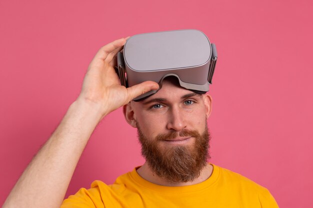 Hombre guapo con barba se quita el fondo de estudio de gafas vr