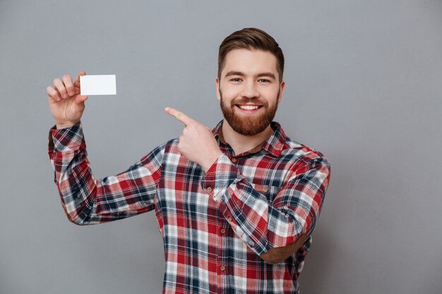 Hombre guapo con barba con tarjeta en blanco