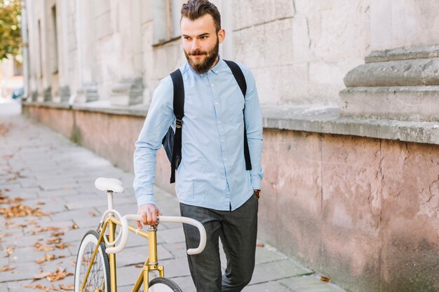 Hombre guapo, bicicleta que camina