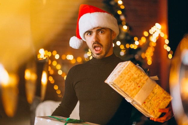 Hombre guapo con cajas de regalos de navidad