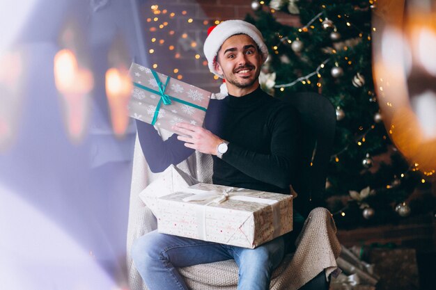 Hombre guapo con cajas de regalos de navidad