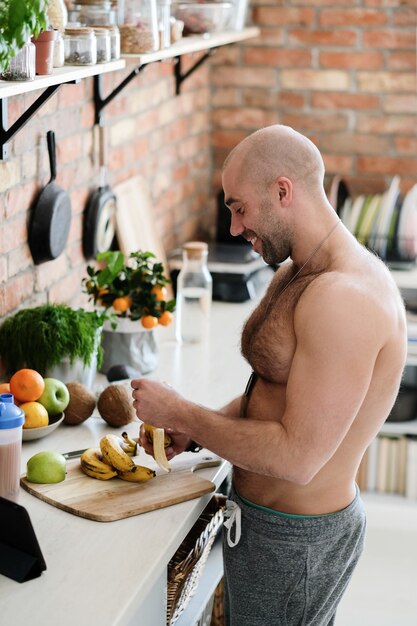 Hombre guapo, sin camisa en la cocina