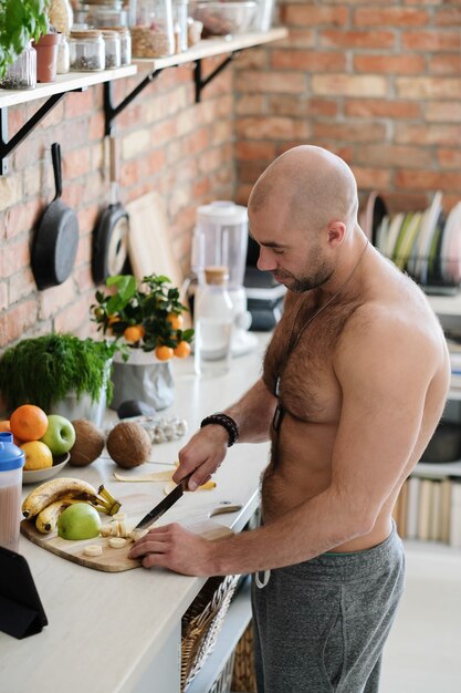 Hombre guapo, sin camisa en la cocina