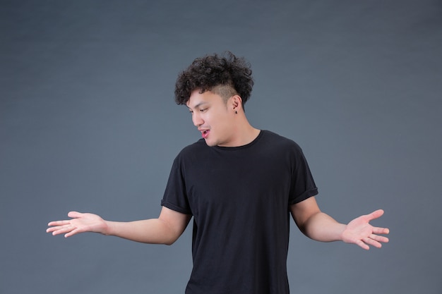 Un hombre guapo con una camisa negra de pie con los brazos