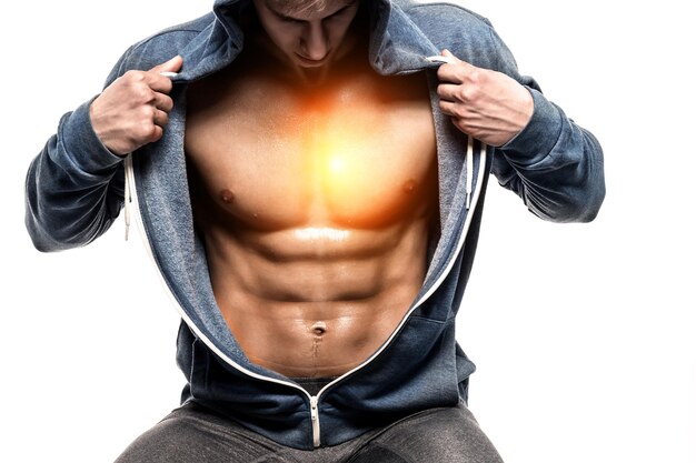 Hombre guapo con chaqueta abierta que revela pecho musculoso y abdominales, aislado en fondo blanco