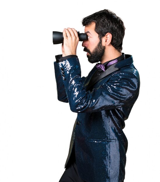 Hombre guapo con chaqueta de lentejuelas con binoculares