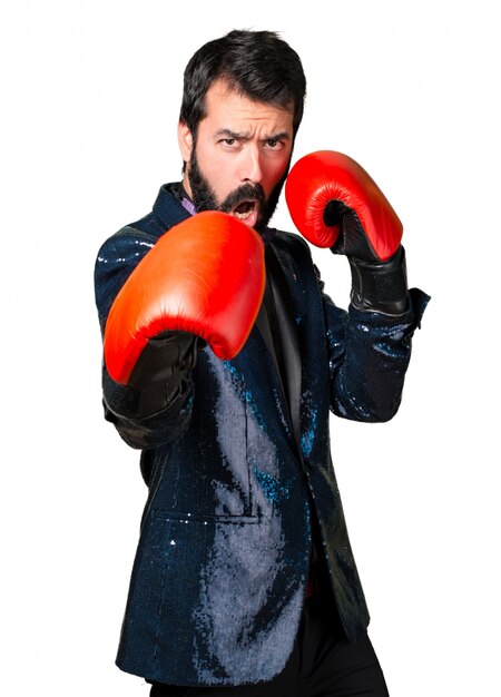 Hombre guapo con chaqueta de lentejuelas con guantes de boxeo