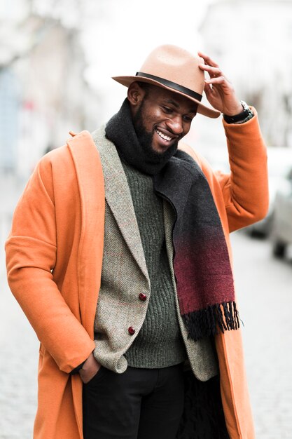 Hombre guapo en chaqueta naranja posando al aire libre