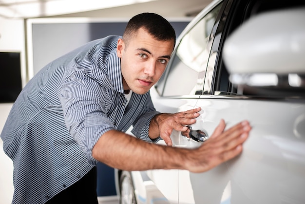 Foto gratuita hombre guapo comprobando un coche