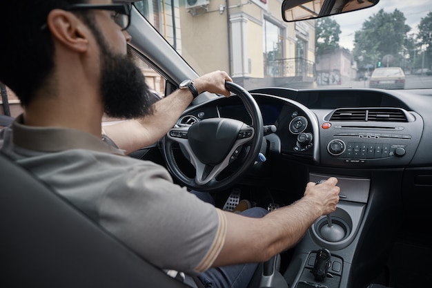 Hombre guapo conduciendo el coche