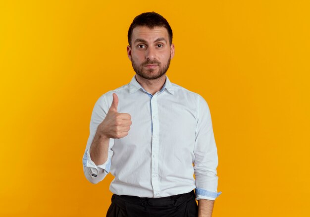 Hombre guapo confiado pulgar hacia arriba aislado en la pared naranja