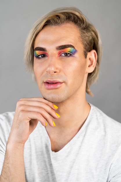 Hombre guapo con cosméticos de maquillaje y esmalte de uñas