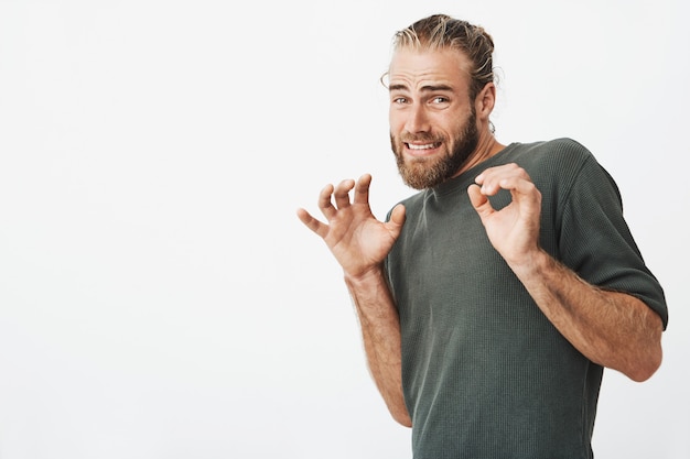 Hombre guapo con elegante cabello y barba gritando con expresión asustada