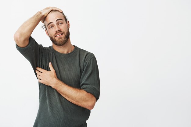 Hombre guapo con elegante peinado y barba con expresión feliz