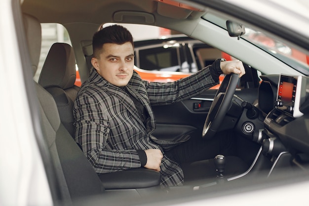 Hombre guapo y elegante en un salón del automóvil