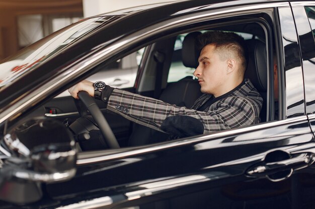 Hombre guapo y elegante en un salón del automóvil