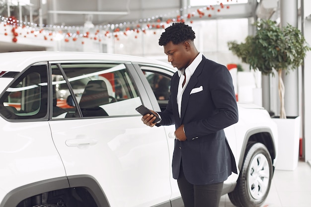 Hombre guapo y elegante en un salón del automóvil