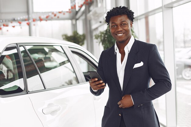 Hombre guapo y elegante en un salón del automóvil