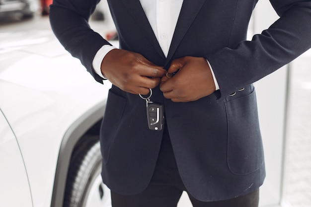 Hombre guapo y elegante en un salón del automóvil