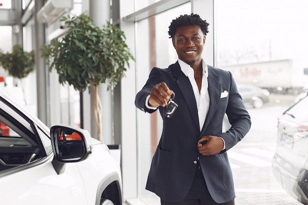 Hombre guapo y elegante en un salón del automóvil