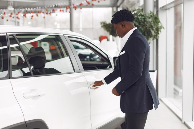 Hombre guapo y elegante en un salón del automóvil