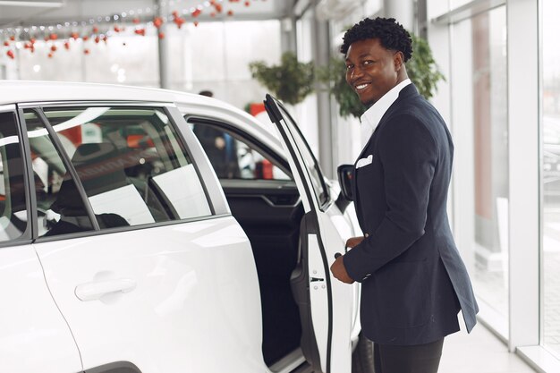 Hombre guapo y elegante en un salón del automóvil