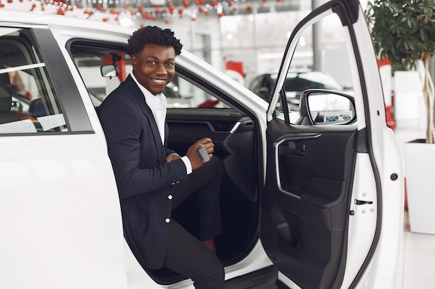 Hombre guapo y elegante en un salón del automóvil