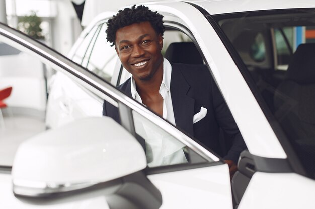 Hombre guapo y elegante en un salón del automóvil