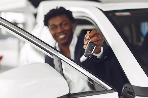 Hombre guapo y elegante en un salón del automóvil