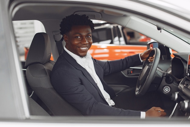 Hombre guapo y elegante en un salón del automóvil