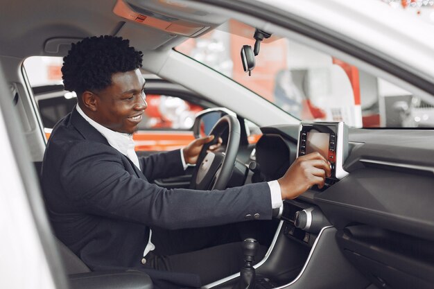 Hombre guapo y elegante en un salón del automóvil