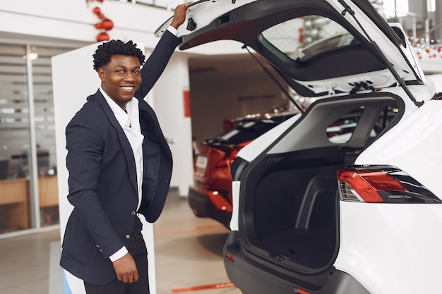 Hombre guapo y elegante en un salón del automóvil