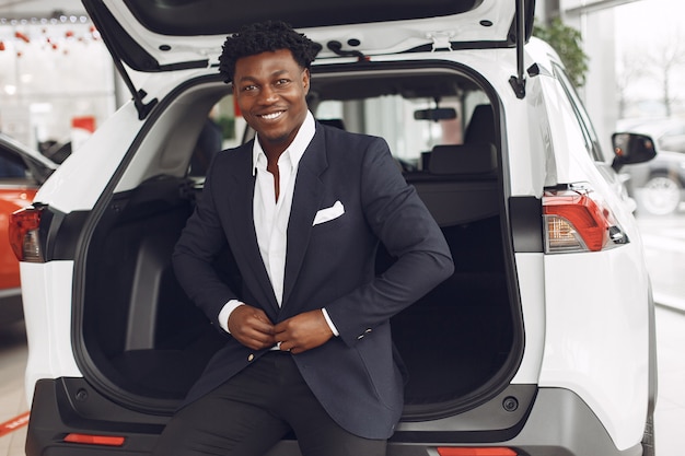 Hombre guapo y elegante en un salón del automóvil