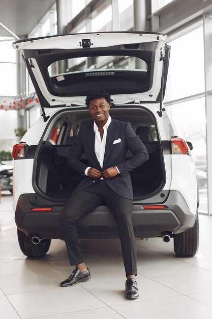 Hombre guapo y elegante en un salón del automóvil